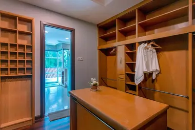 a walk in closet with wooden shelves and a wooden table at 325 Ritchie by COBNB at Ampang in Kuala Lumpur