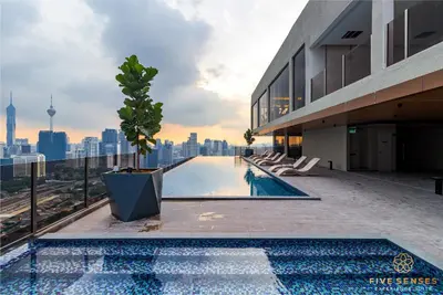 a swimming pool on the roof of a building with a city skyline at Armani Residence KLCC in Kuala Lumpur