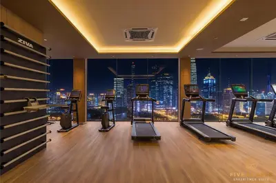 a gym with a view of a city at night at Armani Residence KLCC in Kuala Lumpur