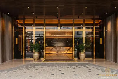 a lobby with two potted plants in front of a building at Armani Residence KLCC in Kuala Lumpur