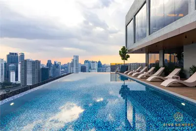 a pool on the roof of a building with a city skyline at Armani Residence KLCC in Kuala Lumpur