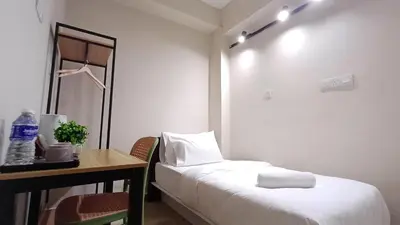 a hotel room with a bed and a table and a desk at Swing and Pillows - ICC Pudu Kuala Lumpur in Kuala Lumpur