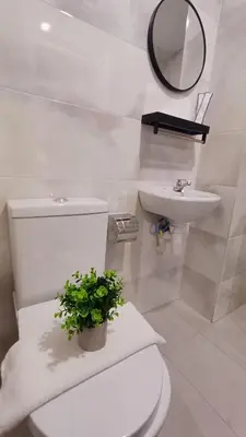 a white bathroom with a toilet and a sink at Swing and Pillows - ICC Pudu Kuala Lumpur in Kuala Lumpur