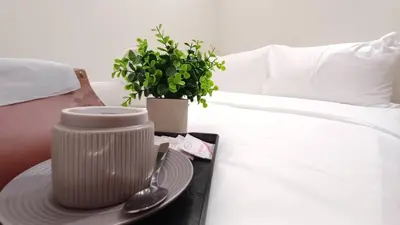 a table with a plate and a plant on a bed at Swing and Pillows - ICC Pudu Kuala Lumpur in Kuala Lumpur