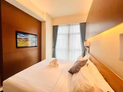 a bedroom with a large white bed with a window at Tribeca Homestay Bukit Bintang TRX in Kuala Lumpur