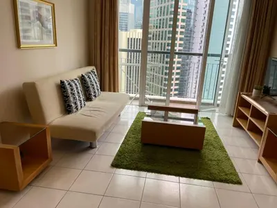 a living room with a chair and a large window at Grand suites at Seri Bukit Ceylon in Kuala Lumpur