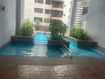 a swimming pool in a building with potted plants at Grand suites at Seri Bukit Ceylon in Kuala Lumpur
