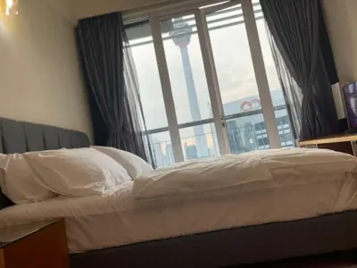 a bed in a room with a large window at Grand suites at Seri Bukit Ceylon in Kuala Lumpur