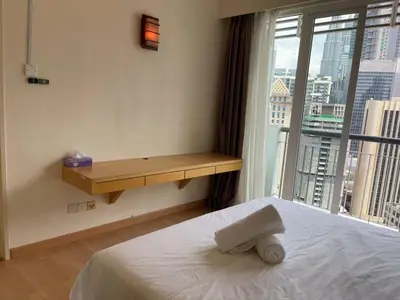a bedroom with a bed with a desk and a window at Grand suites at Seri Bukit Ceylon in Kuala Lumpur
