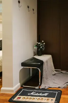 a black stool sitting next to a table with flowers at Chic Cityscape Homestay in Bukit Bintang 1-5 people in Kuala Lumpur