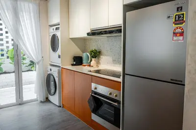 a kitchen with a refrigerator and a washer and dryer at Terasek Terrace with Private Pool in Kuala Lumpur