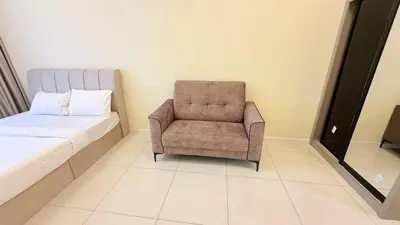 a bedroom with a chair next to a bed at majestic Resort Suites KLCC At Bukit bintang in Kuala Lumpur