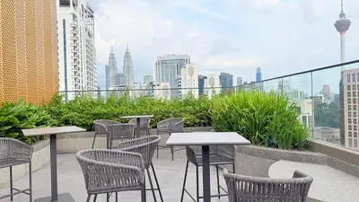 a patio with tables and chairs and a city skyline at majestic Resort Suites KLCC At Bukit bintang in Kuala Lumpur