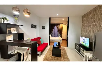 a living room with a red couch and a tv at Taragon Elite Residence in Kuala Lumpur