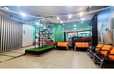 a waiting room with orange chairs and a clock in the middle at Taragon Elite Residence in Kuala Lumpur