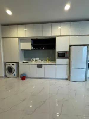 a kitchen with white cabinets and a refrigerator at Platinum Suites KLCC by Home stay in Kuala Lumpur