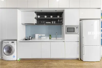 a white kitchen with a refrigerator and a washing machine at Elysian Sky Executive Platinum Suites KLCC in Kuala Lumpur