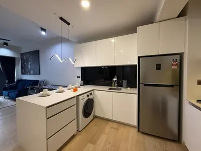 a kitchen with white cabinets and a washer and dryer at Star Residance by Nexus in Kuala Lumpur