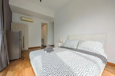 a bedroom with a bed with a black and white comforter at Reizz Residence by Greenhome in Kuala Lumpur