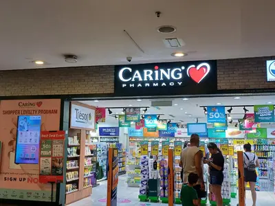 a caring pharmacy store with people standing in front of it at KL Advice Suite At Times Square in Kuala Lumpur