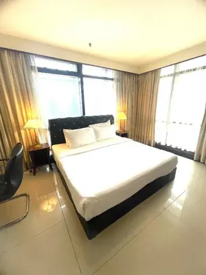 a bedroom with a large white bed with large windows at Sunrise Residence At Berjaya Times Square AR in Kuala Lumpur