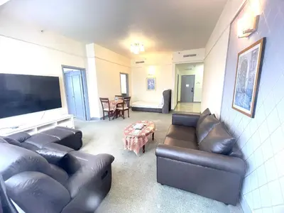 a living room with leather furniture and a flat screen tv at Sunrise Residence At Berjaya Times Square AR in Kuala Lumpur