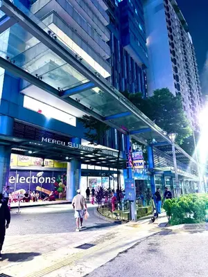a group of people walking in front of a building at Mercu Summer suites KLCC by JK Privy Homes - 7 Pax Family Stay in Kuala Lumpur