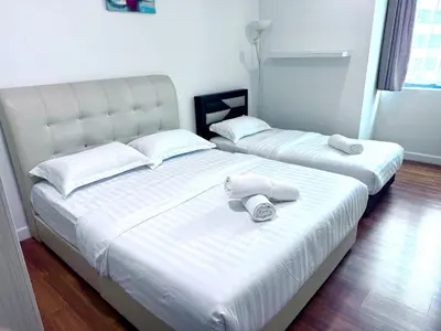 two beds with towels on top of them in a bedroom at Mercu Summer suites KLCC by JK Privy Homes - 7 Pax Family Stay in Kuala Lumpur