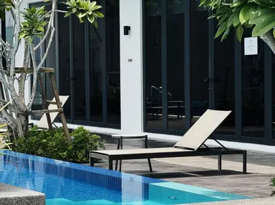 a chair next to a swimming pool next to a building at Majestic Suites KLCC by KLIQ in Kuala Lumpur