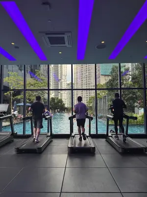 a group of people on a treadmill looking at the water at KL Star Residance by Nexus 52 in Kuala Lumpur