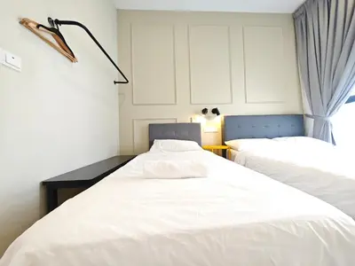 two beds in a room with white sheets at TRION The 107 Family Suites POOL VIEW in Kuala Lumpur