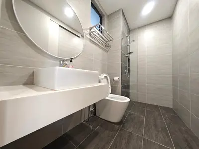 a bathroom with a sink and a mirror and a toilet at TRION The 107 Family Suites POOL VIEW in Kuala Lumpur