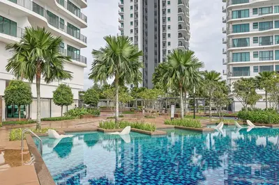a swimming pool with palm trees and buildings at Elegant Skyline Suite Datum Jelatek near KLCC in Kampong Datok Keramat
