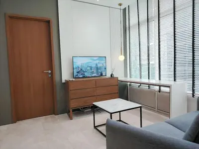 a living room with a couch and a table and a door at KLCC Luxe High speed wifi 2BR Residence in Kuala Lumpur