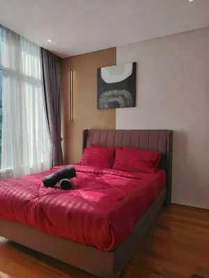 a bedroom with a large red bed with red pillows at KLCC Luxe High speed wifi 2BR Residence in Kuala Lumpur