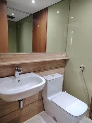 a bathroom with a sink and a toilet and a mirror at KLCC Luxe High speed wifi 2BR Residence in Kuala Lumpur
