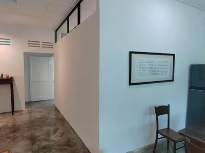 a white wall with a chair and a picture on it at Zen Retreat KL in Kuala Lumpur