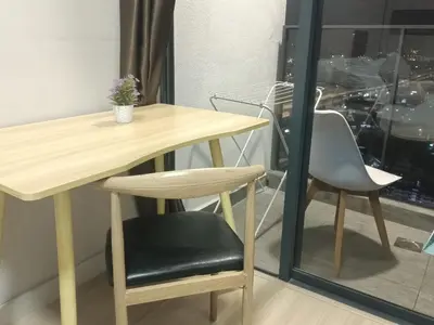 a wooden table and a chair next to a window at Continew Residence by TM House in Kuala Lumpur