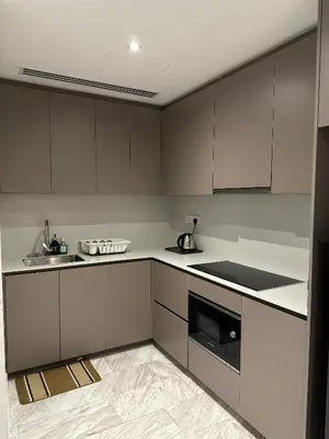 a kitchen with white cabinets and a sink and a stove at Eaton Residence KLCC by Majestic Hospitality in Kuala Lumpur
