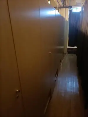 an empty room with a row of doors and a wooden floor at Cozy Hostel City Central in Kuala Lumpur