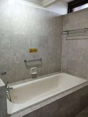 a bath tub in a bathroom with a sign on the wall at Royal Service Suite At Berjaya Times Square in Kuala Lumpur