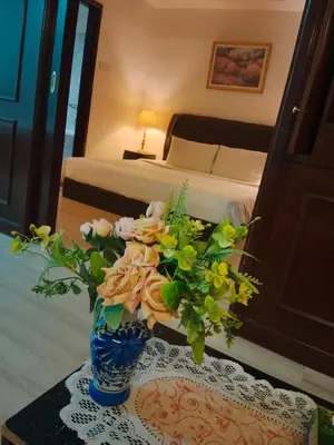 a vase with flowers on a table in a bedroom at The Signature Suites at Berjaya Times Square KL in Kuala Lumpur