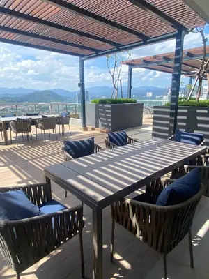 a wooden table and chairs with a view of the ocean at Neu Suite by Triple A in Kuala Lumpur