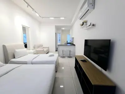 a hotel room with two beds and a flat screen tv at City centre Majestice Suite KLCC in Kuala Lumpur
