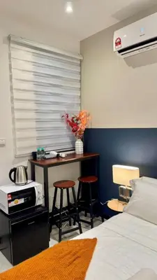 a bedroom with a desk with two stools and a bed at Cozy, Mini Studio Apartment at Neu Suites by OKBnB in Kuala Lumpur