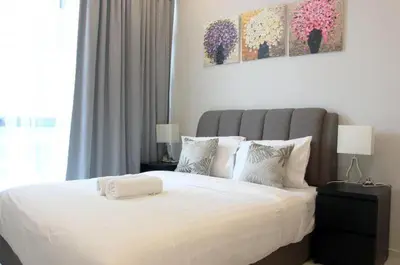 a bedroom with a large bed with white sheets and pillows at park view one bedroom apartment klcc in Kuala Lumpur