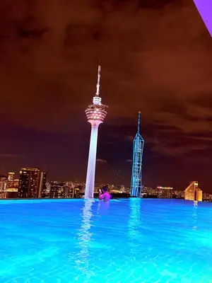 a infinity pool with a view of a city at night at PLATINUM Suites KLCC at BBS in Kuala Lumpur