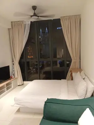 a bedroom with a white bed and a large window at Majestic Residence Kuala Lumpur in Kuala Lumpur