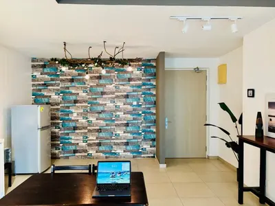 a laptop on a table in a room with a brick wall at Reizz Residence by Willow Trip in Kuala Lumpur