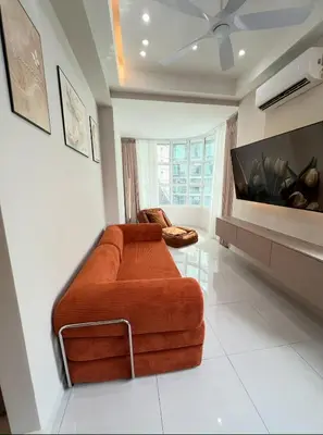 a living room with an orange couch and a tv at Parkview Serviced Apartment in Kuala Lumpur